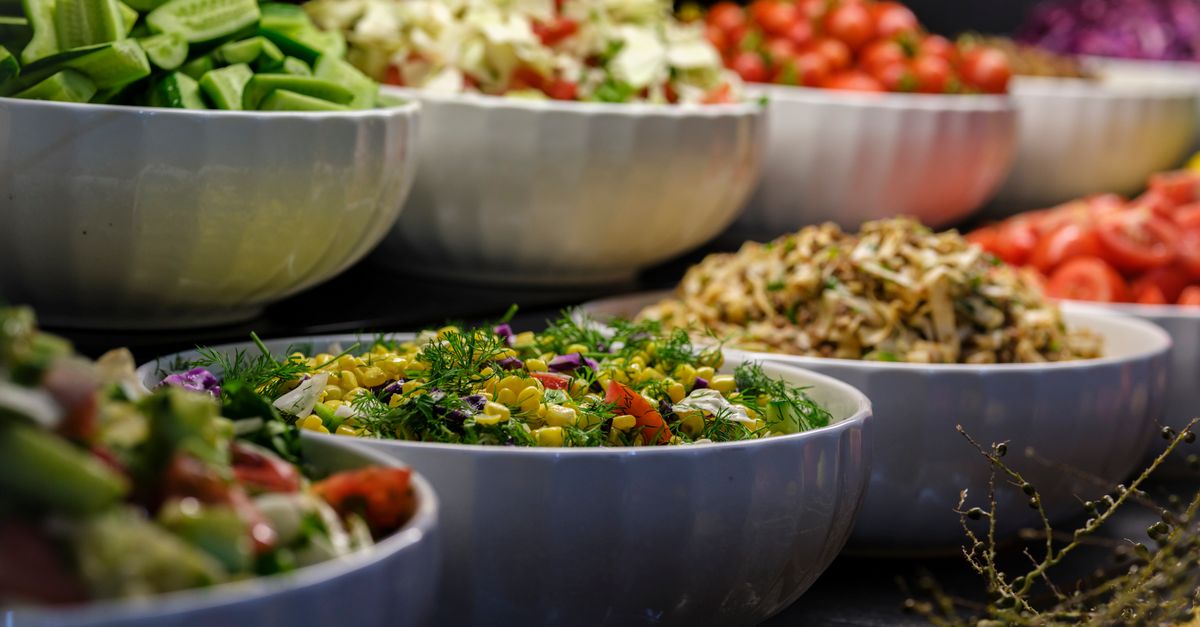 A colorful assortment of fresh salads and vegetables in ceramic bowls. Perfect for healthy food photography.